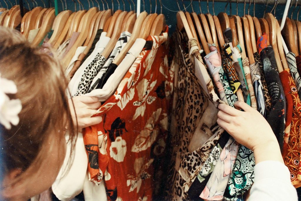 woman browsing blouses on a clothes rack