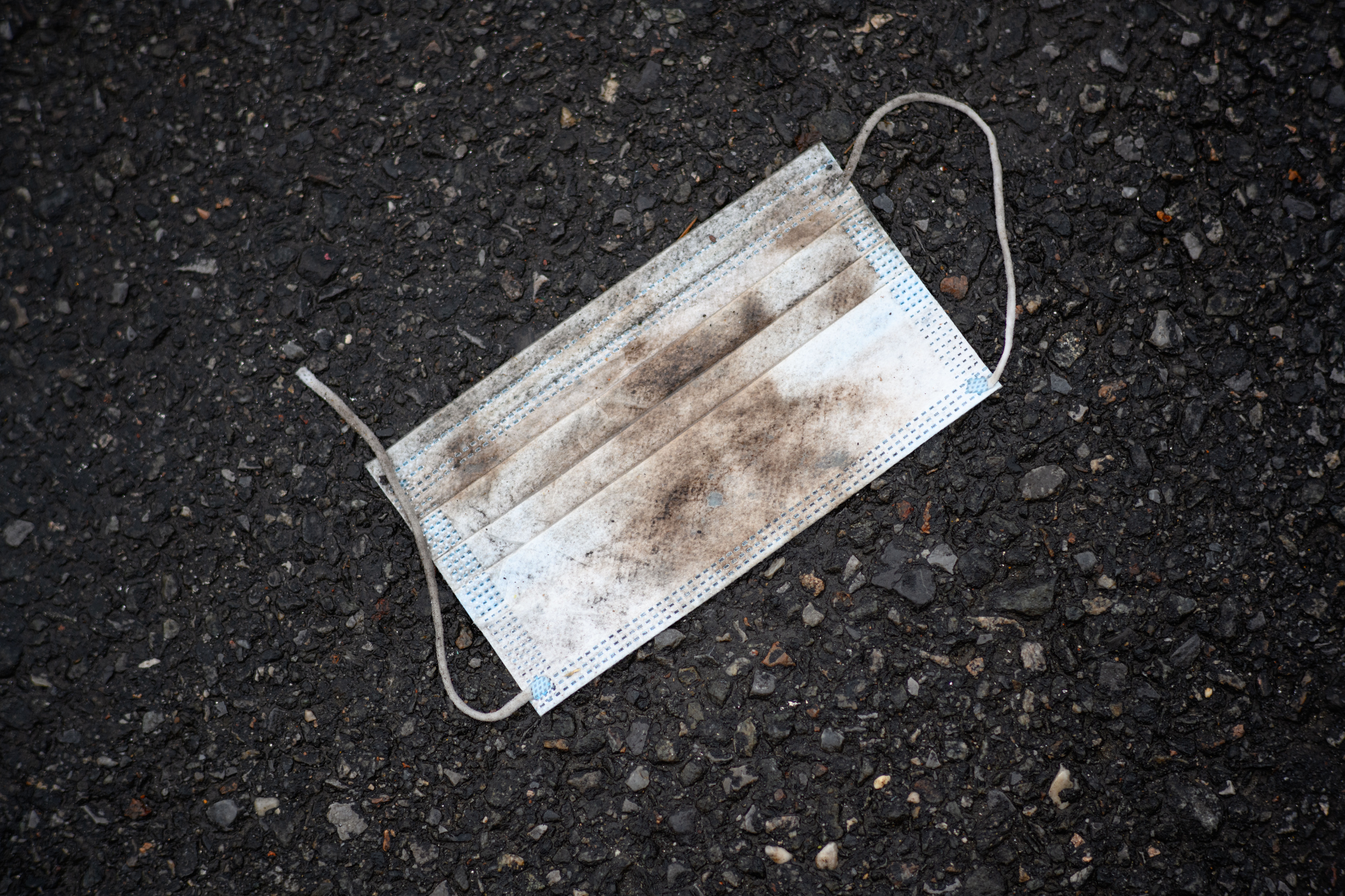 disposable face mask left on the ground