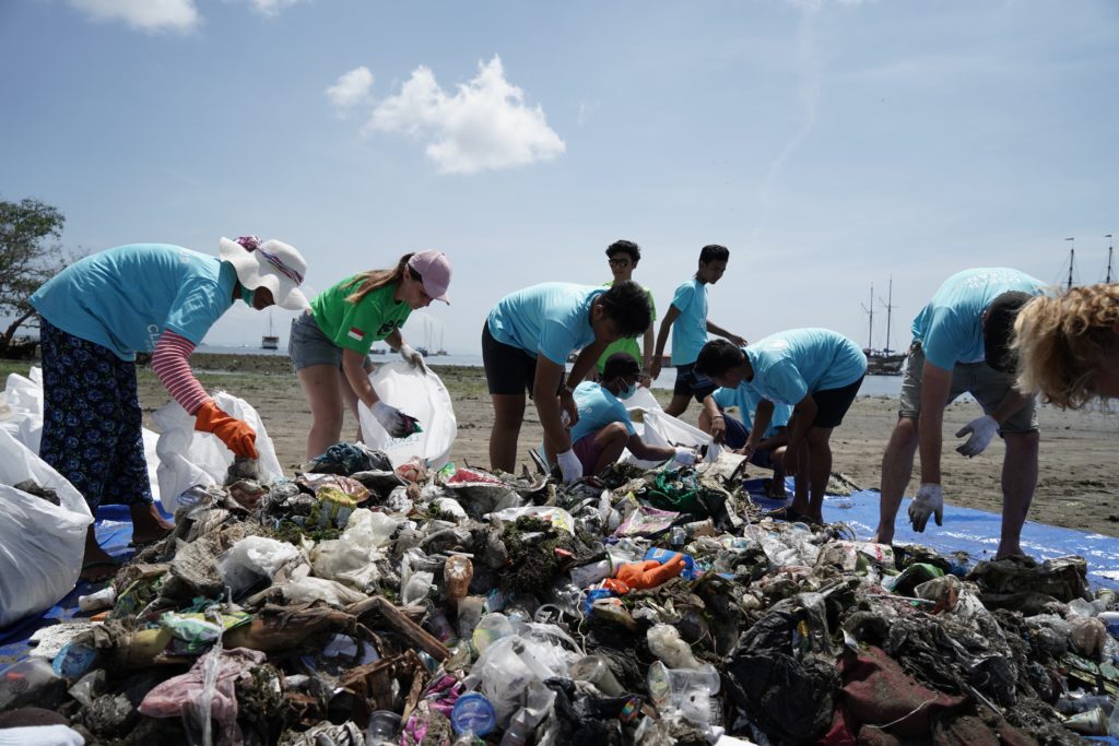 volunteers picking up trash by the ocean