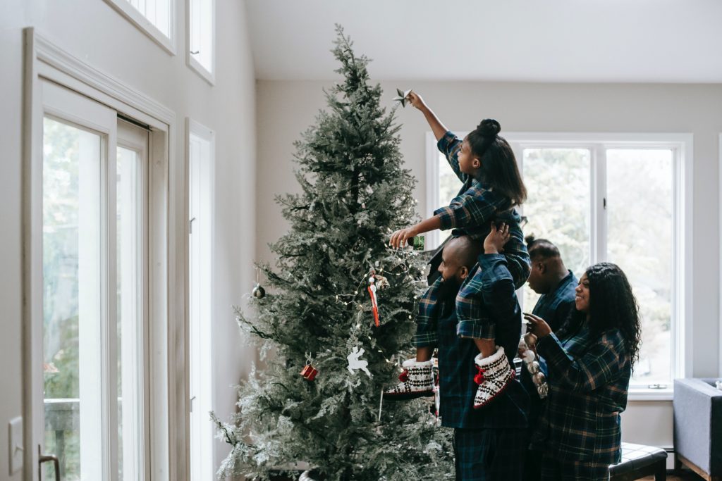 family putting a star on top of a tree