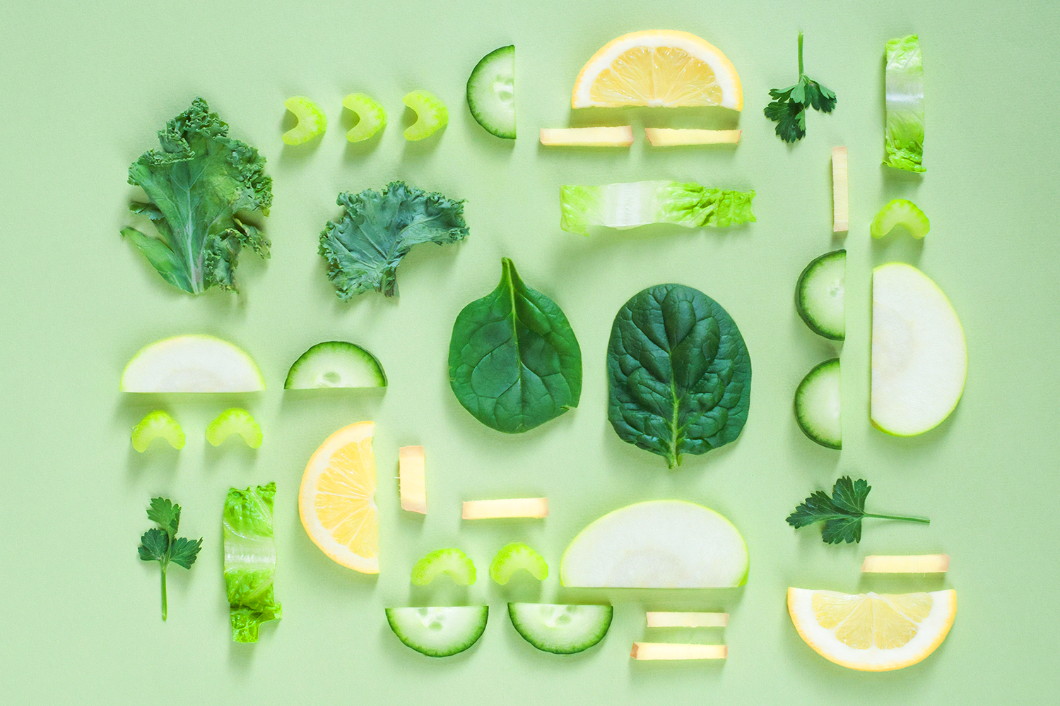 flatlay of green fruits and veggies over green background